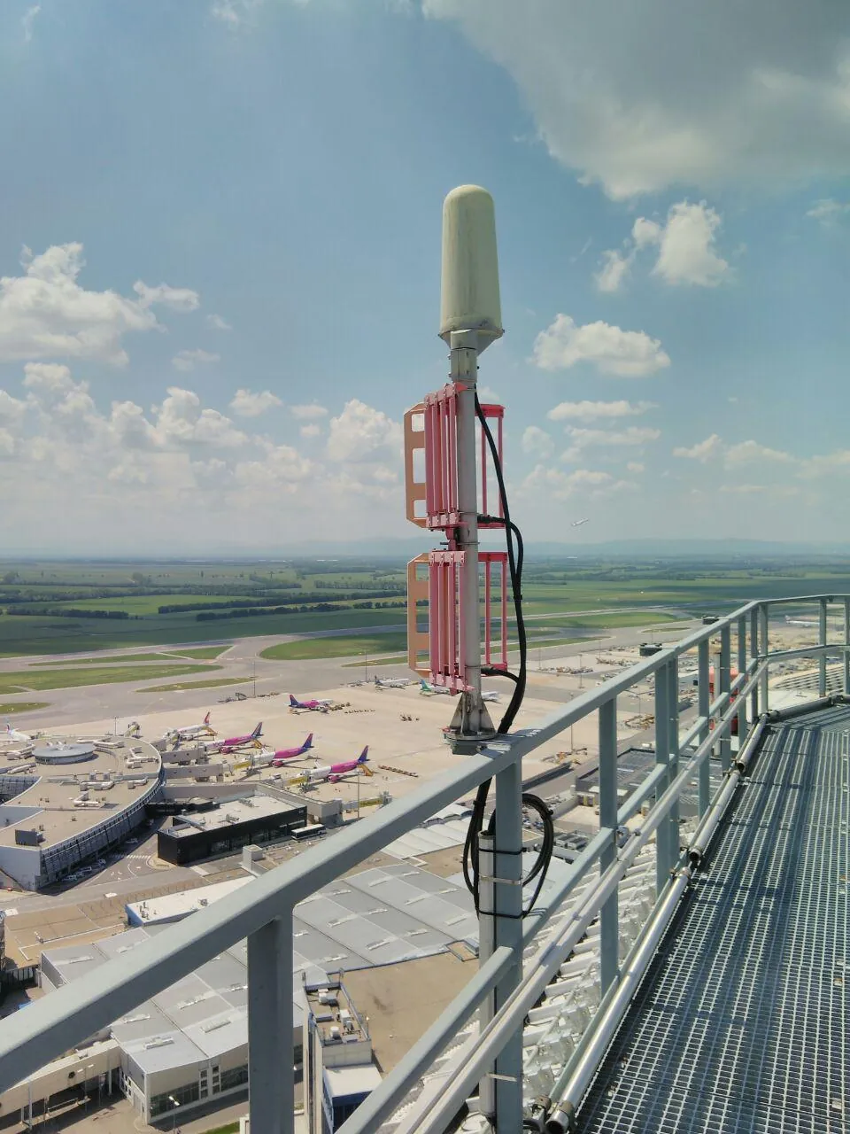 Montierte Antennenanlage in der Höhe mit Blick auf ein Flughafenvorfeld